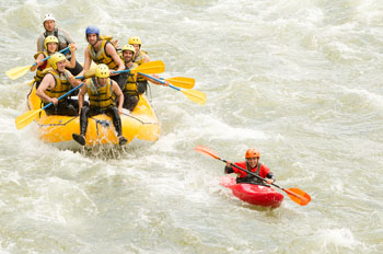 Image of rafting team supporting a kayaker